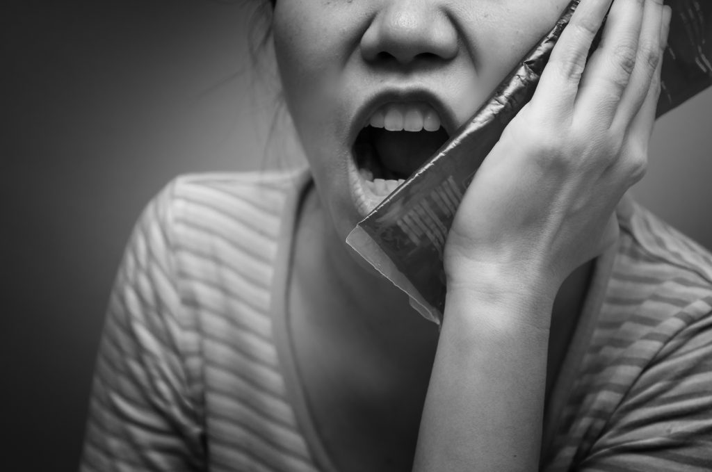 Asian woman suffering from toothache and using cold pack jelly. Black and white tone. Concept of teeth problem.