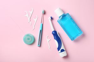Flat lay composition with toothbrushes and oral hygiene products on color background