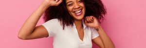 Young african american woman isolated on pink background dancing and having fun.