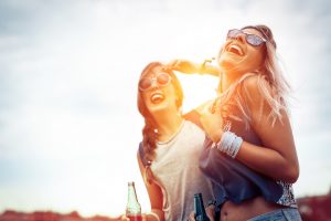 Happy friends laughing and having fun outdoors at concert