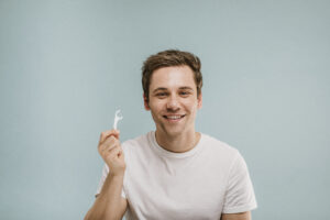 Cheerful man showing a dental floss pick