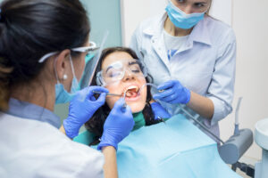 Two dental doctors and patient. Procedure at the dentist office.