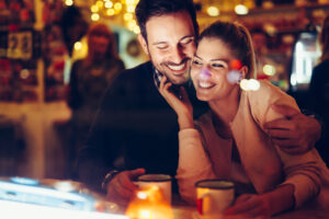 Romantic young couple dating in pub at night