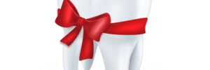 tooth with red bow on white background