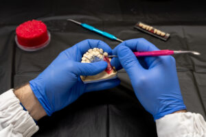 Dental technician or dentist working with tooth dentures in his laboratory