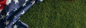 top view of american flag with stars and stripes on green grass outside, labor day concept