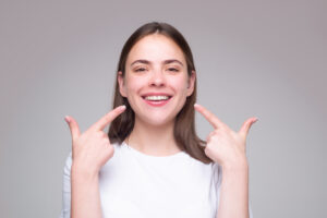 Beautiful woman pointing to teeth. Beautiful smile with white teeth. Closeup smiling woman mouth. Dental health