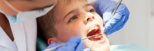 dentist examining boys teeth close up