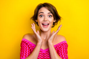 Girl with bob haircut smiling on yellow background